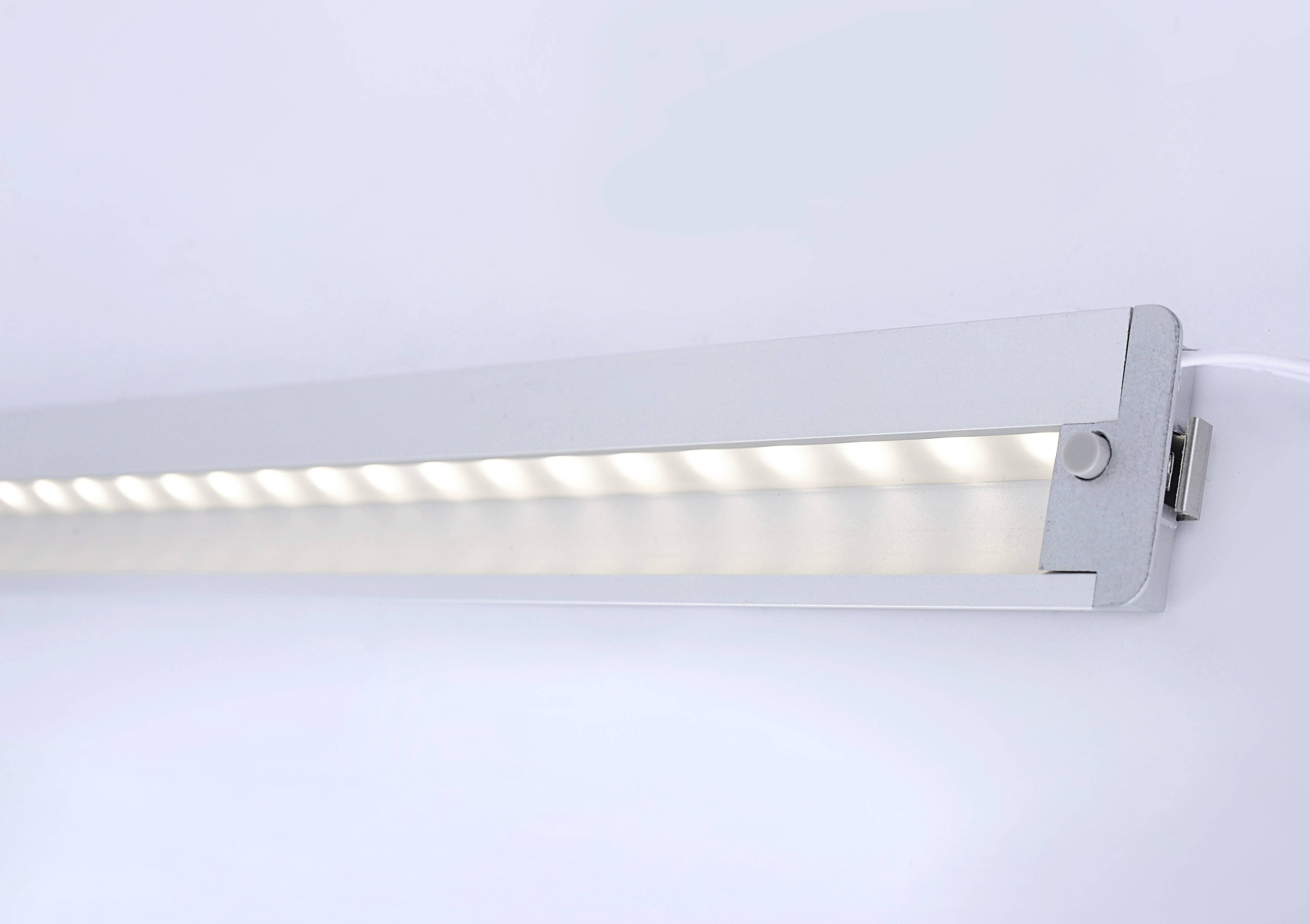 Moderna LED traka svjetla u jednostavnom kućištu svijetli neutralnim bijелim tonom, postavljena na zidu.