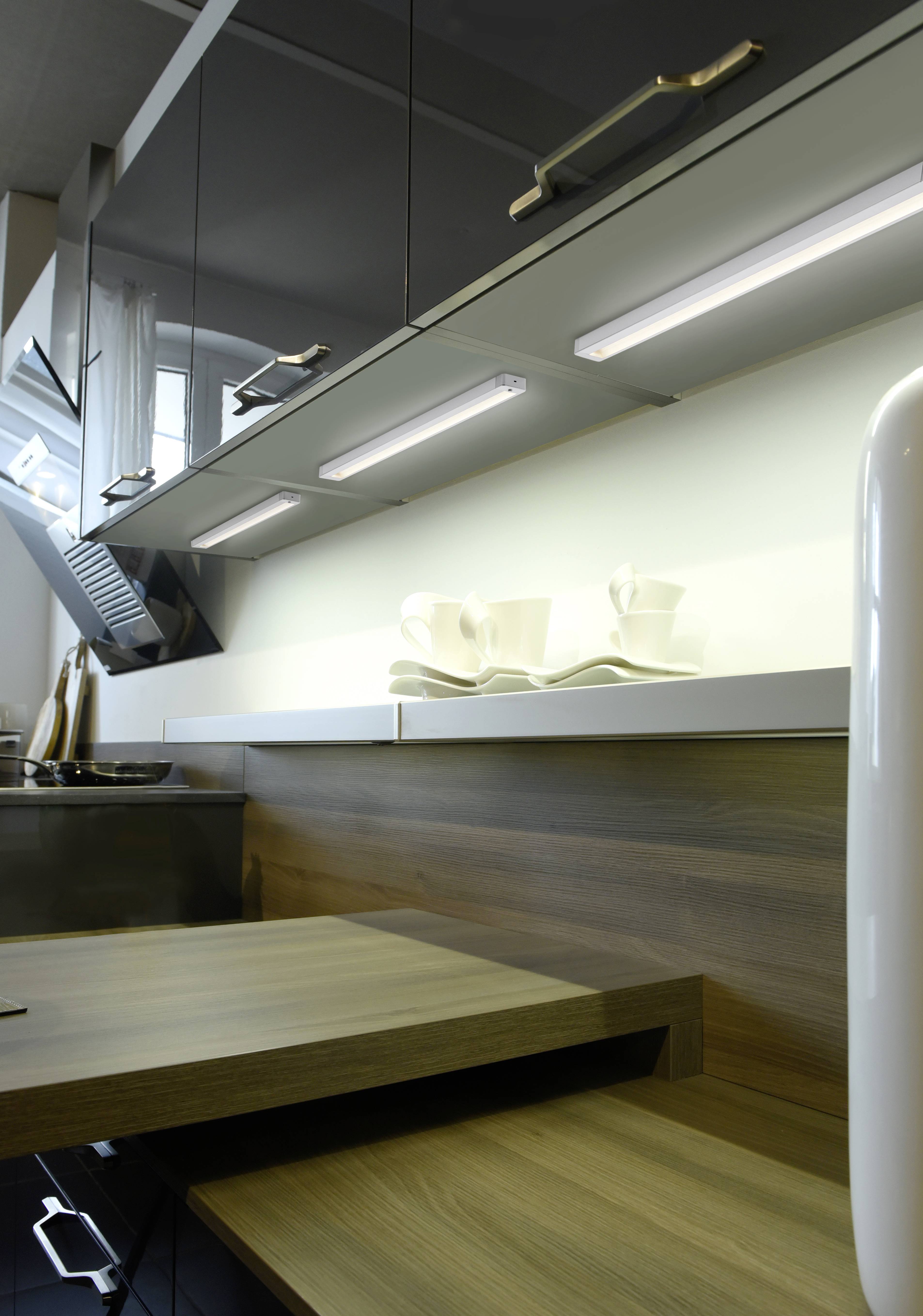 Moderna kuhinja s drvenom radnom površinom, viseći ormarići i odabrani kuhinjski pribor; stilski i funkcionalno uređena.