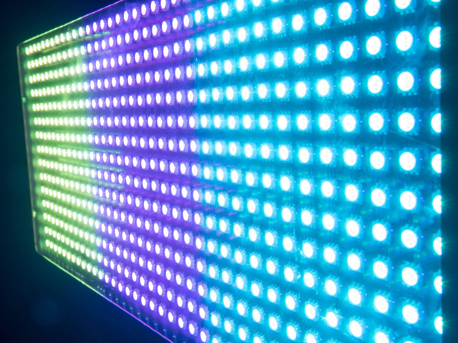 LED-svjetlosni zid u različitim bojama: Zelena, plava, ljubičasta. Širokokutni pogled koji stvara futurističko i živahno ozračje.