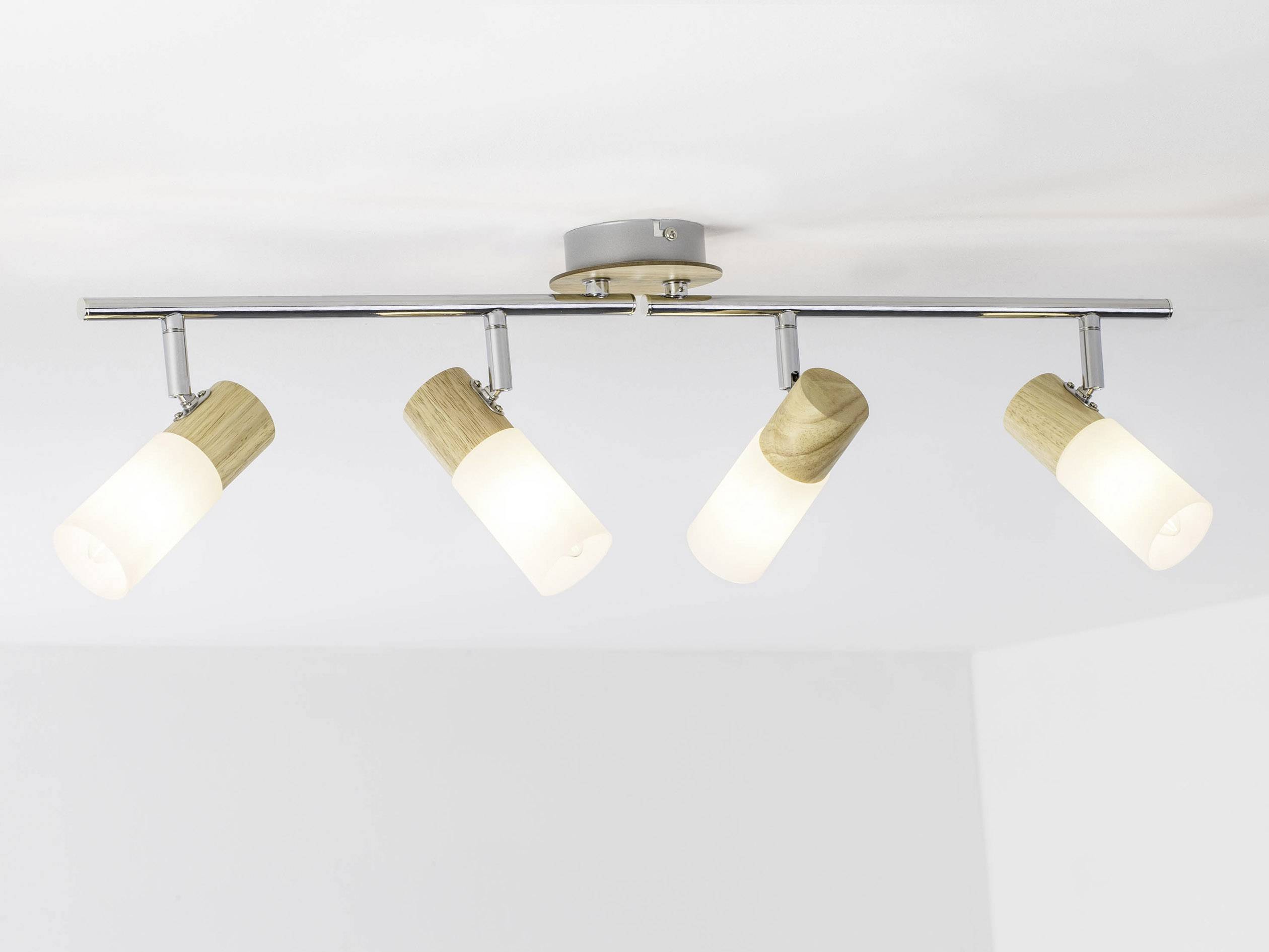 Moderna stropna lampa s četiri podesive reflektora u drvu i bijelom staklu, pričvršćena na metalnoj šini na stropu.