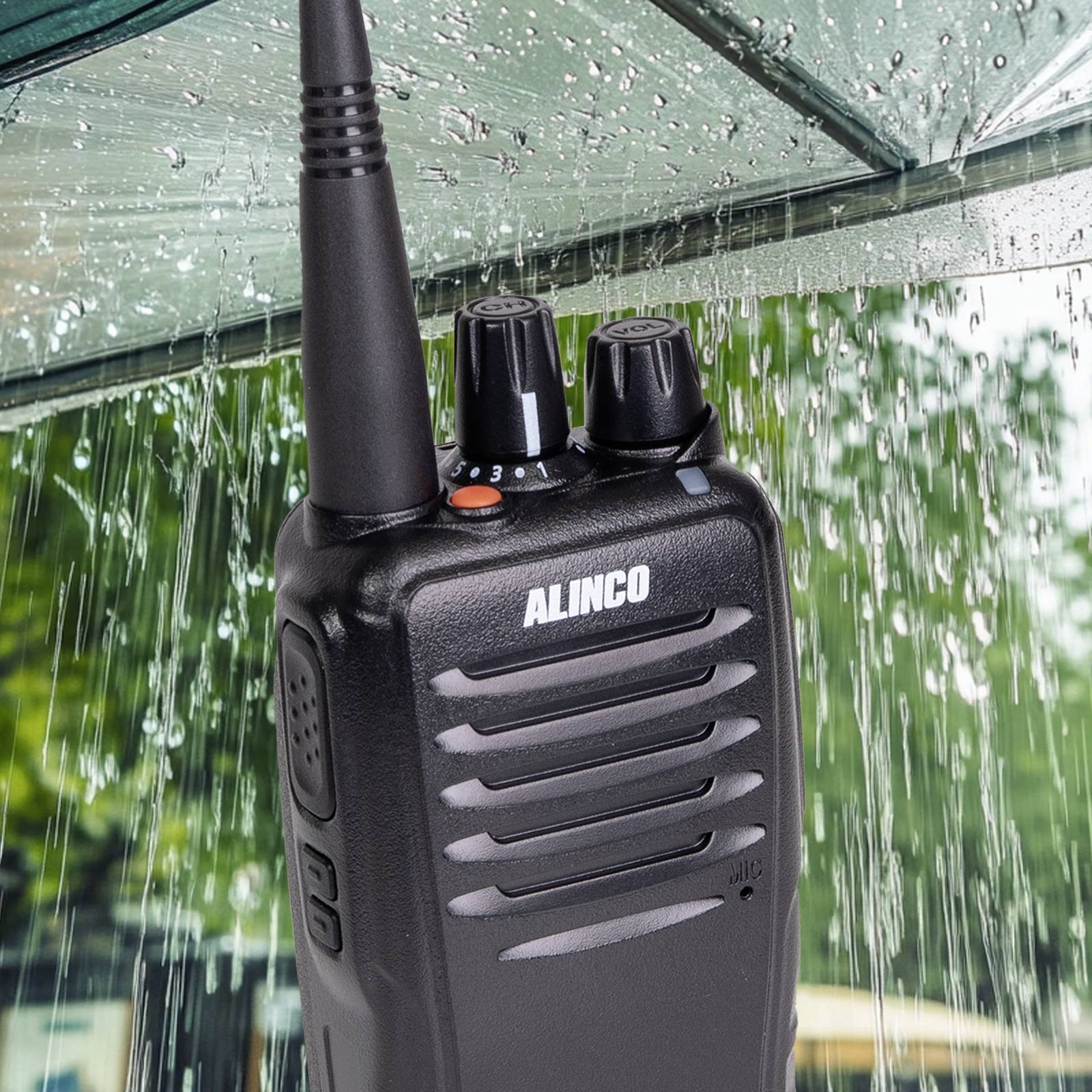 Alinco radio uređaj se vidi na kiši ispod staklenog krova. Vodootporan je, što naglašava njegovu čvrstu i otpornu prirodu.