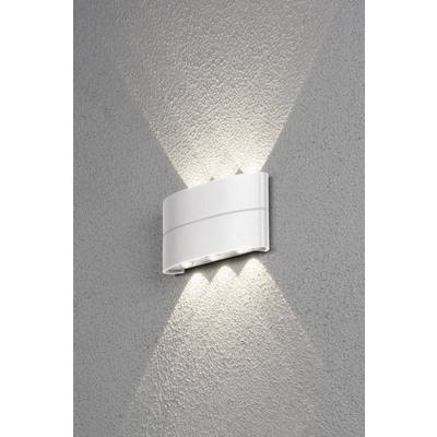 Bijela zidna lampa emitira svjetlost gore i dolje na sivi zid, stvarajući dekorativan uzorak.