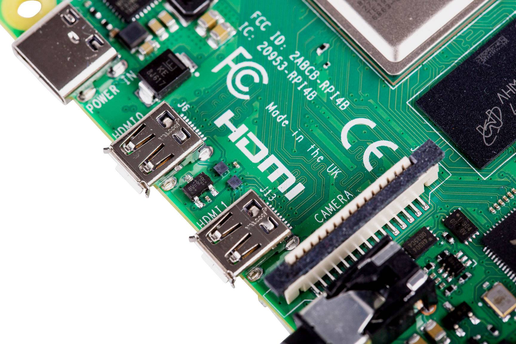Bliski kadar zelene matične ploče jednoplohodnog računala s HDMI i USB priključcima, brojnim elektroničkim komponentama i priključkom za kameru.