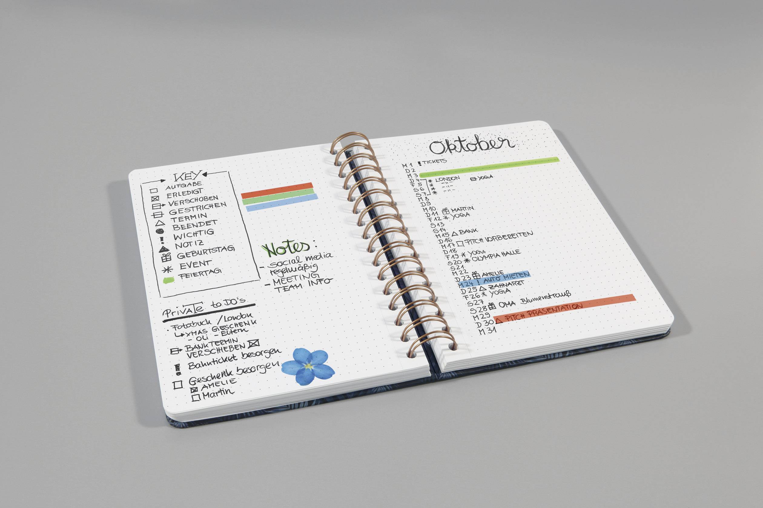 Otvoreni rokovnik-kalendar s obojenim registrima, lista zadataka i bilješkama za listopad. Sadrži termine i pregled mjeseca.