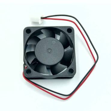 Mali crni ventilator s sedam lopatica i dvije žice, crvenom i crnom, za električno napajanje.