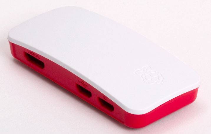 Raspberry Pi kućište u crvenoj i bijeloj boji, s vidljivim priključcima, leži na svijetloj površini.
