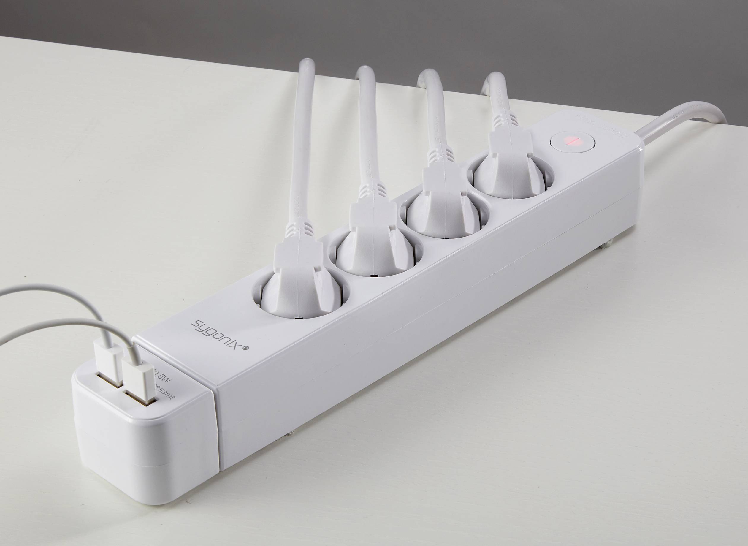 Bijela električna razvodna letva s pet priključnih mjesta i crvenom indikatorskom lampom. Dva USB kabela spojena su s lijeve strane.