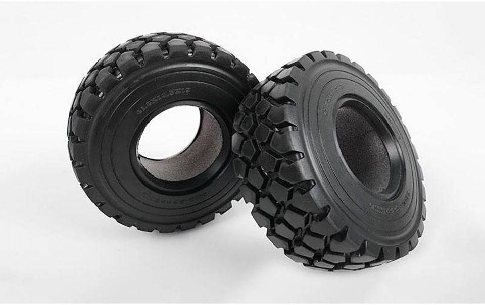 Dva velika, crna off-road guma grubog profila leže jedna pokraj druge na neutralnoj pozadini.