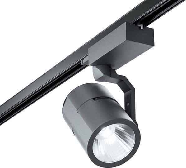 Crni stropni reflektor cilindričnog tijela lampe, montiran na šini, usmjerava svjetlo prema dolje.