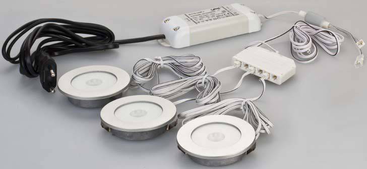 Tri okrugle LED-svjetiljke s kabelima i vanjskim transformatorom, spremne za postavljanje.