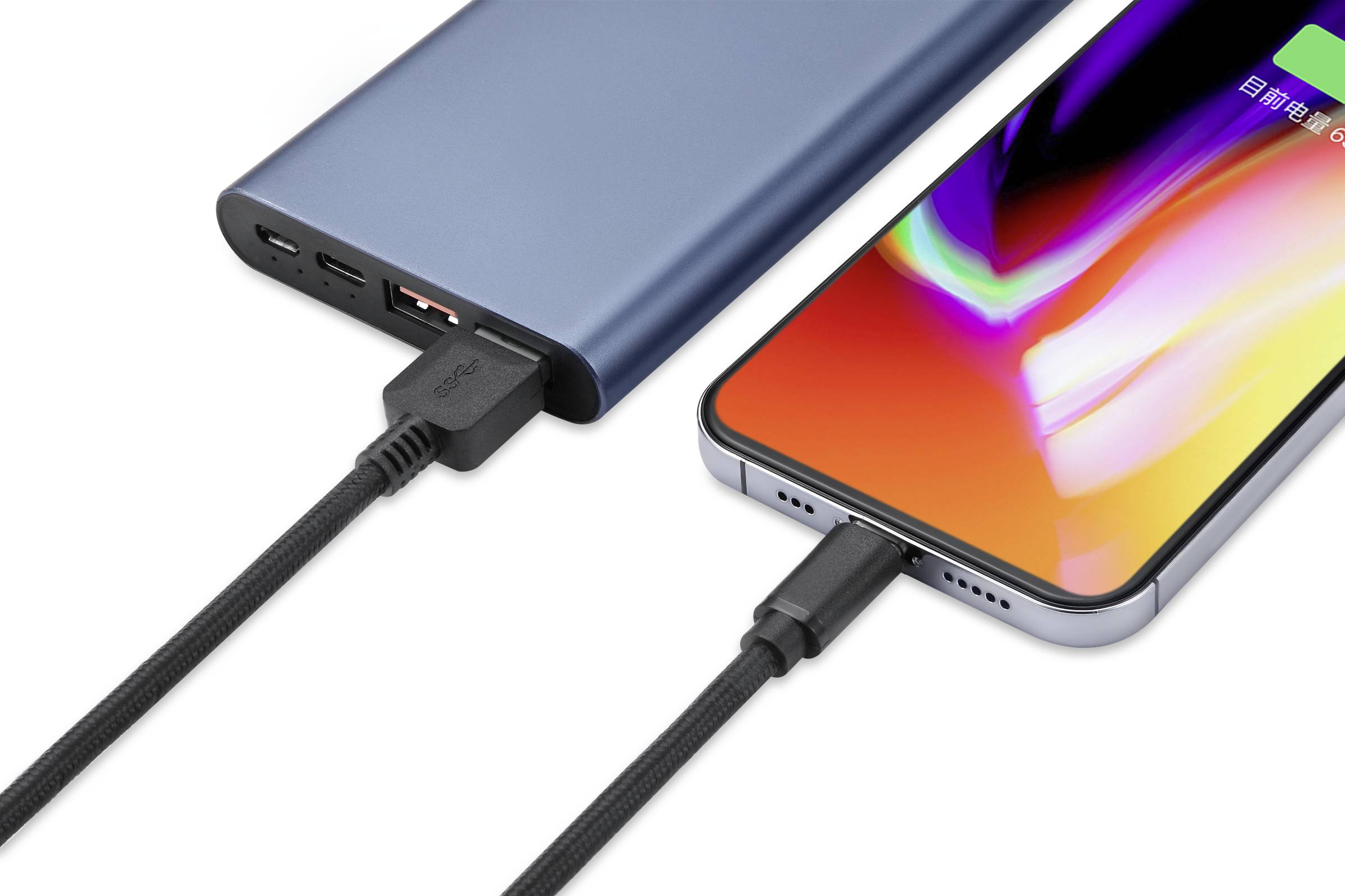 Smartphone se punjač na prijenosnoj bateriji pomoću dva različita kabela, jedan crni i pleteni, drugi standardno crni.