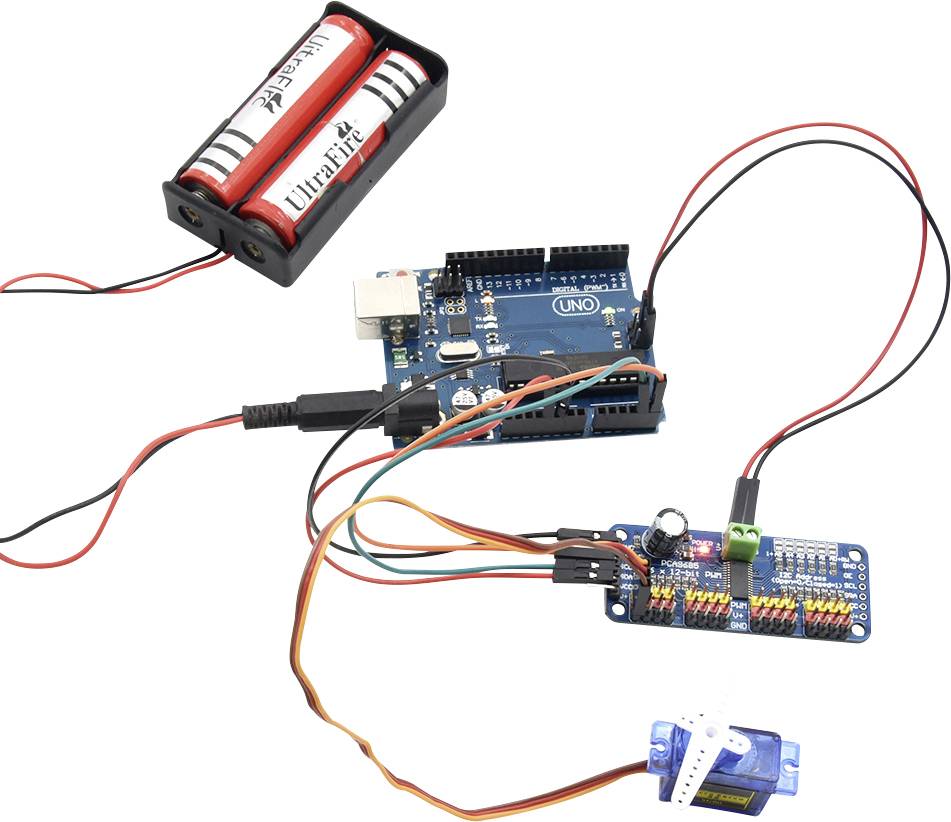 Slika Arduino ploče, povezane s upravljačem motora i servo motorom, napajane baterijskim stalkom s dvije baterije.