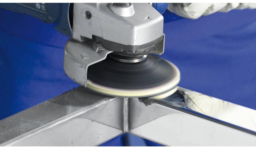 Brusilica se koristi za poliranje metalnog ruba. Jedna ruka vodi stroj preko sjajne površine.