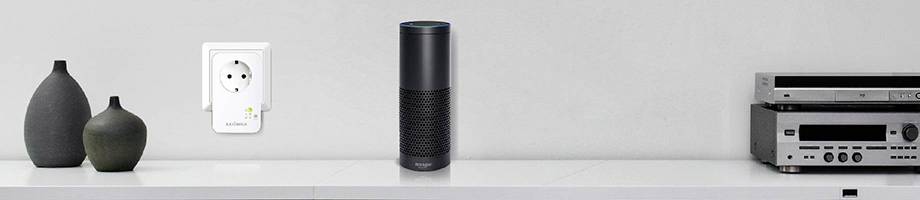 Pametni zvučnik na polici pokraj modernih vaza, utičnice i Hi-Fi sustava.