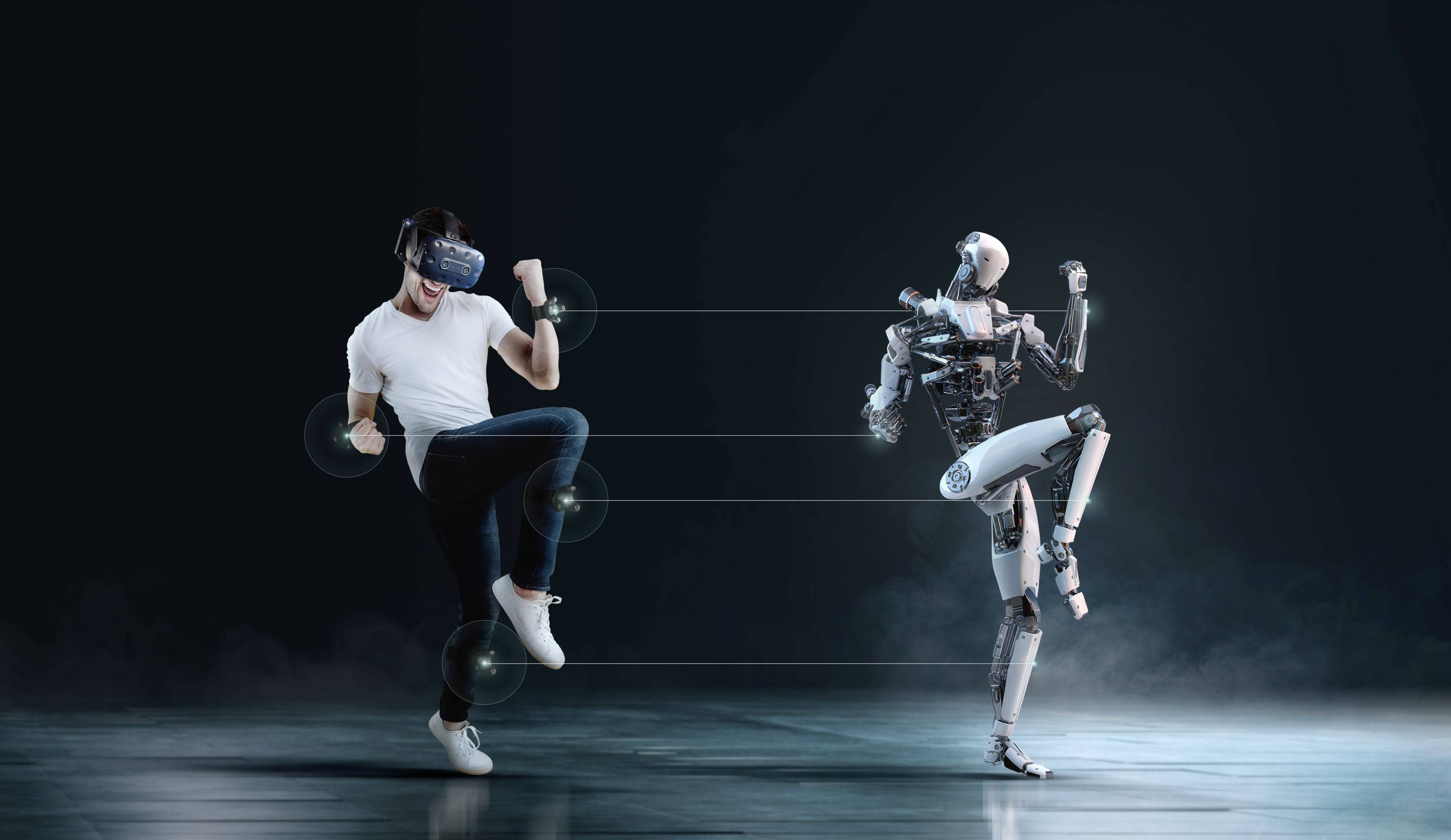 Muškarac s VR naočalama imitira pokrete humanoidnog robota; prikaz tehnologije i ljudske interakcije.