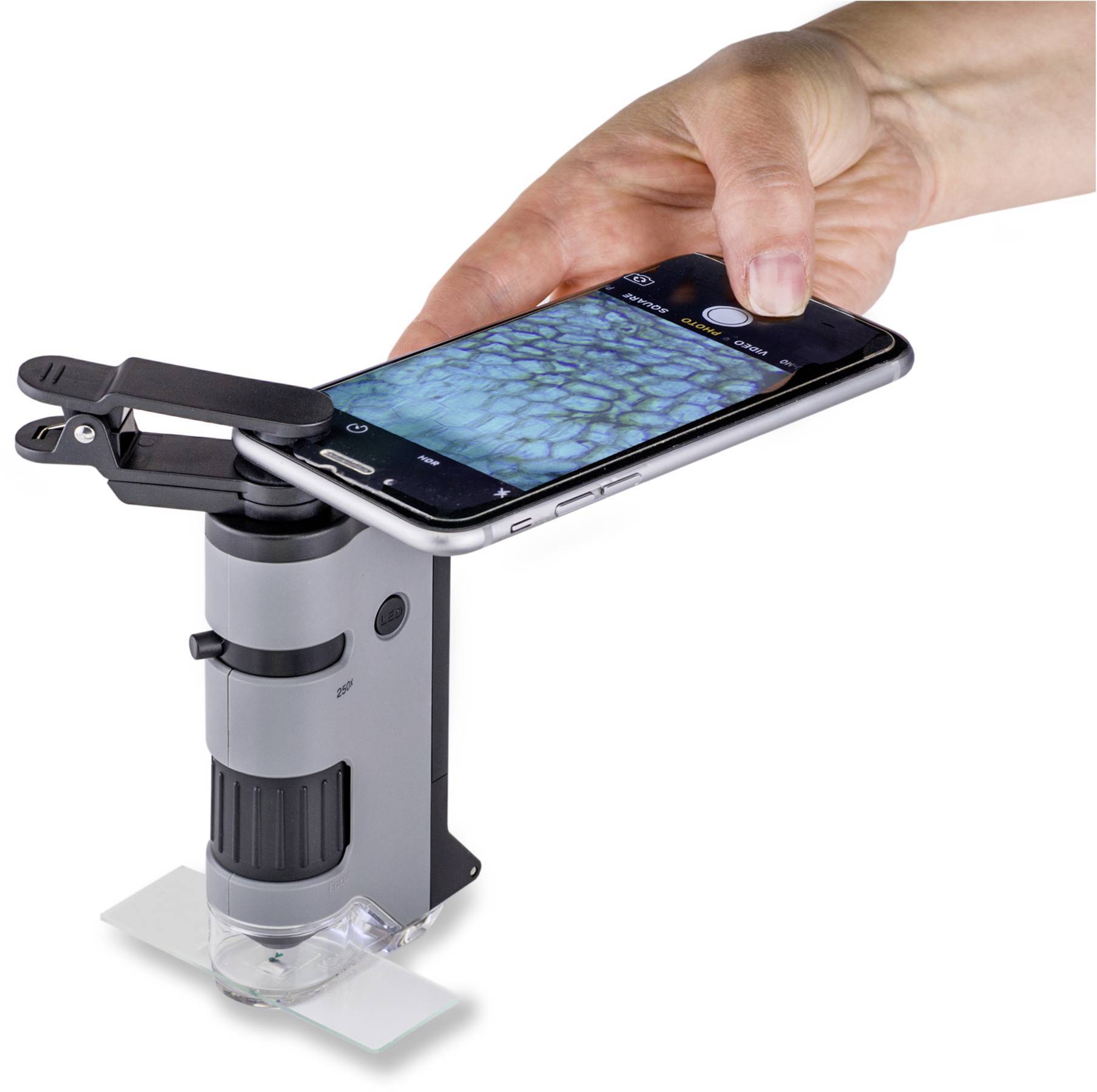 Jedna ruka koristi mikroskopski dodatak za smartphone kako bi prikazala sliku strukture sa plavim i crnim uzorcima na zaslonu.