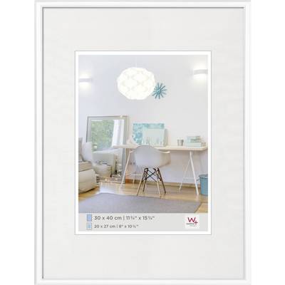 Moderni radni prostor s bijelim stolom, stolcem i dekorativnim elementima. Zrcalo reflektira sofu i prozor.