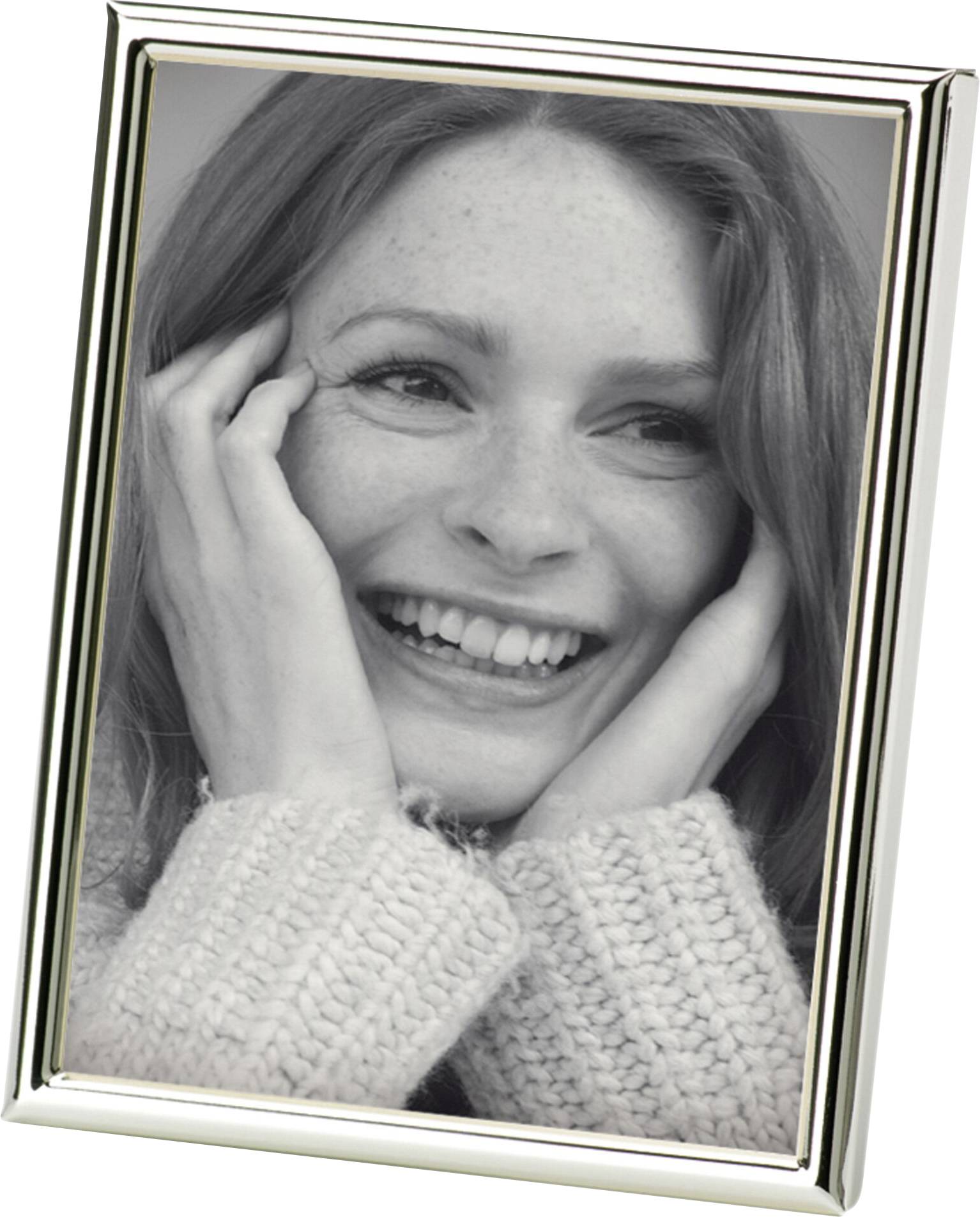 Žena koja se smije drži svoje lice rukama, uokvirena u srebrni okvir za slike.