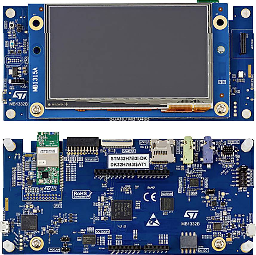 Razvojni mikrokontrolerski board s plavom PCB pločicom i LCD zaslonom na vrhu. Brojni priključci i komponente su vidljivi.