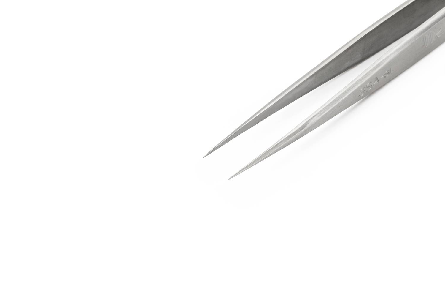 Vrh metalne pincete na bijeloj pozadini, prikazuje precizni alat u bliskom kadru.