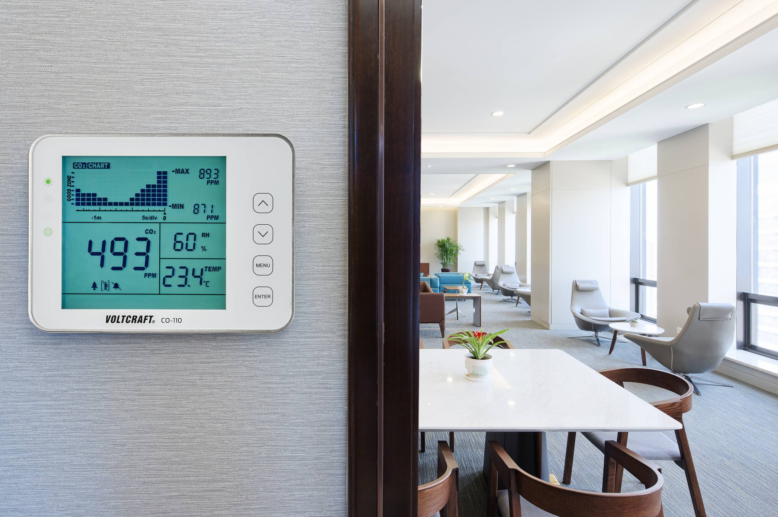Digitalni zidni termostat pokazuje 49,3% vlažnosti zraka i 23,4°C temperature u modernom dnevnom boravku.