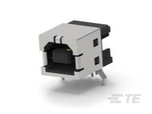 Srebrni, pravokutni elektronički priključak s crnim plastičnim elementima i nekoliko metalnih pinova na donjem dijelu.