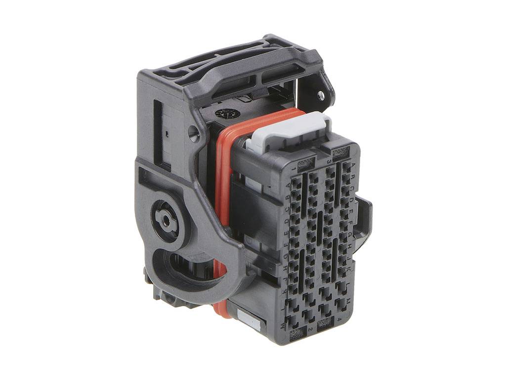 Crni plastični utikač s više pinova i crvenim brtvenim prstenom; služi za električno spajanje komponenata.