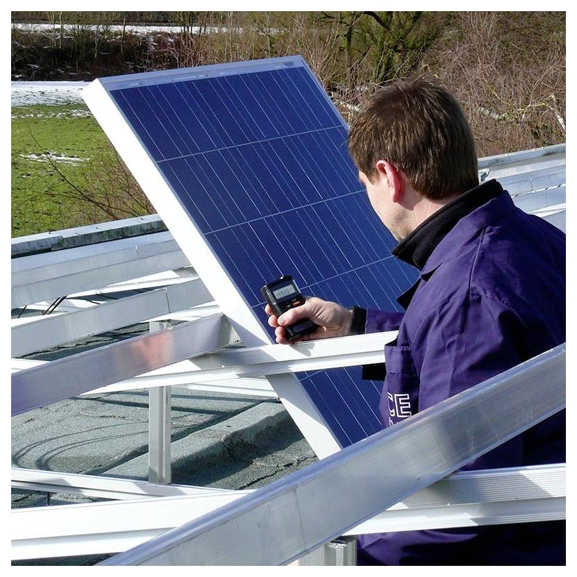 Čovjek inspektira okvir solarnog panela na krovu ručnim mjernim uređajem, provjeri instalaciju.