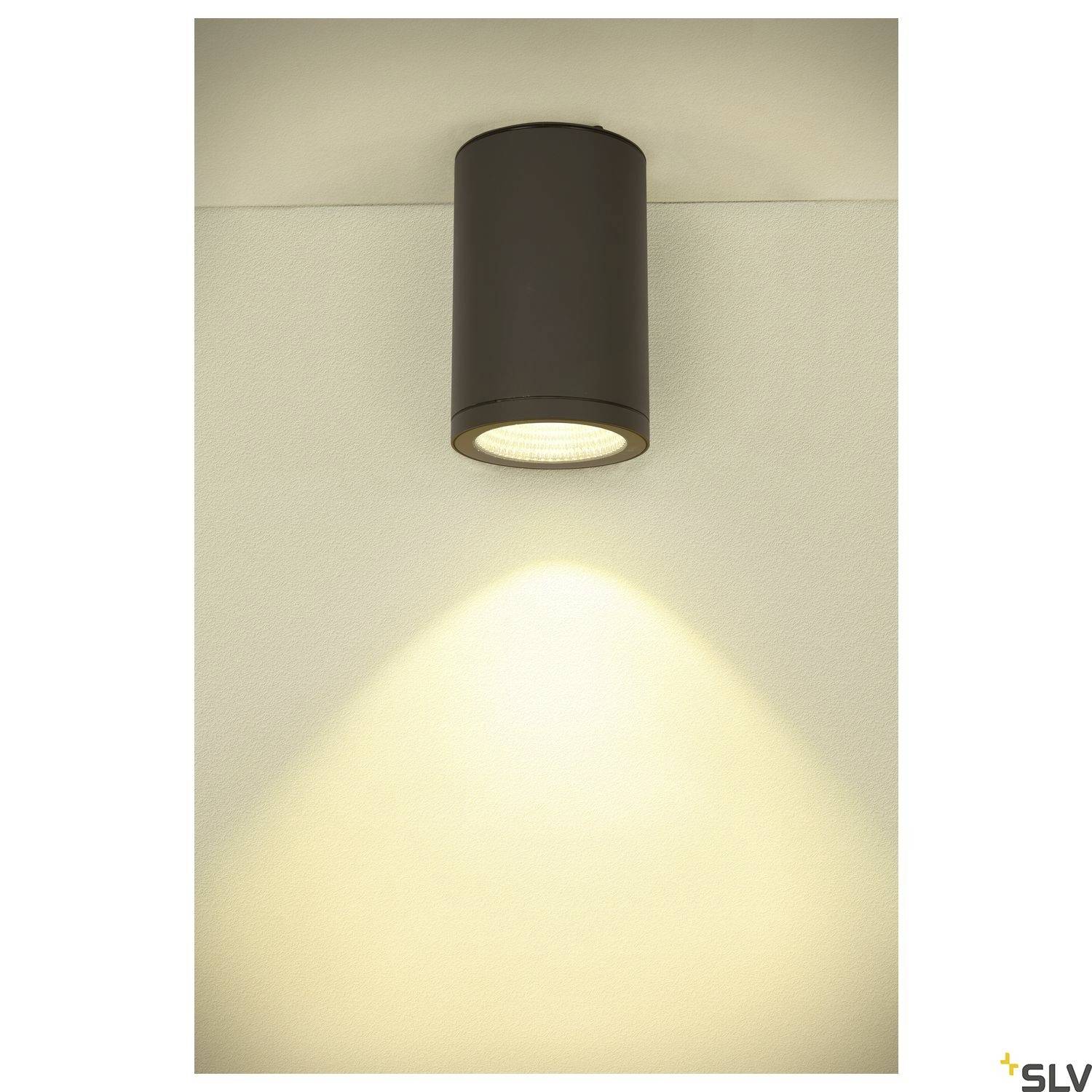 Cilindrična stropna lampa usmjerava izravni svjetlosni snop prema zidu ispod nje.