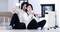 Par sjedi na podu dnevne sobe, smiješi se i drži šalice. Pored njih stoji grijač. Scena djeluje ugodno i toplo.