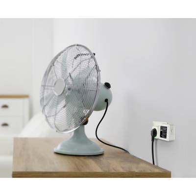 Ventilator stolnog tipa na drvenom stolu priključen je na pametnu utičnicu koja prikazuje podatke o potrošnji električne energije.