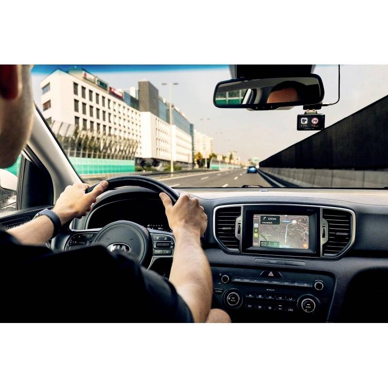 Osoba vozi automobil na autocesti, koristeći navigacijski sustav prikazan na zaslonu.