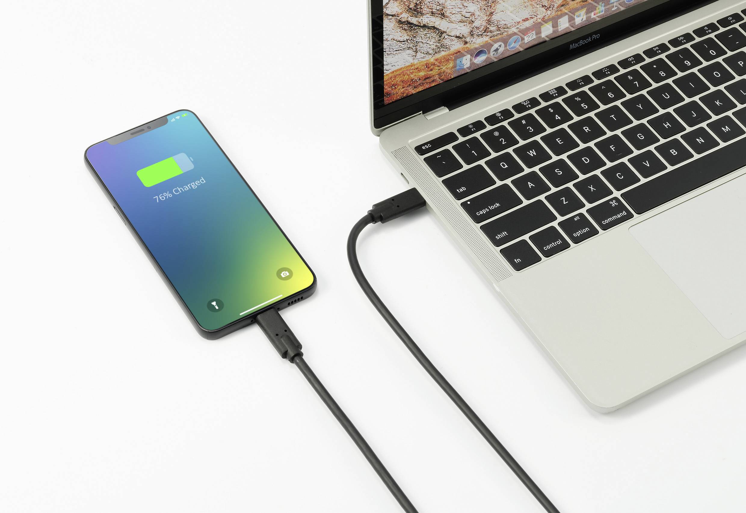 Pametni telefon spojen je USB kabelom na prijenosno računalo i prikazuje '76% napunjeno'. Prijenosno računalo je otvoreno i uključeno.