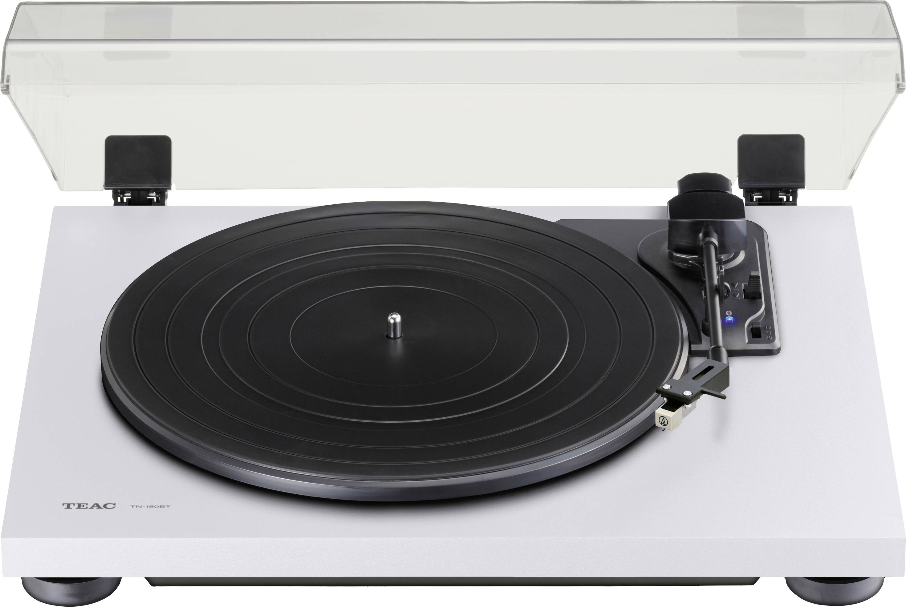 Gramofon s crnom pločom na bijelom kućištu, s prozirnim poklopcem. Tonska ruka je pozicionirana na desnoj strani.