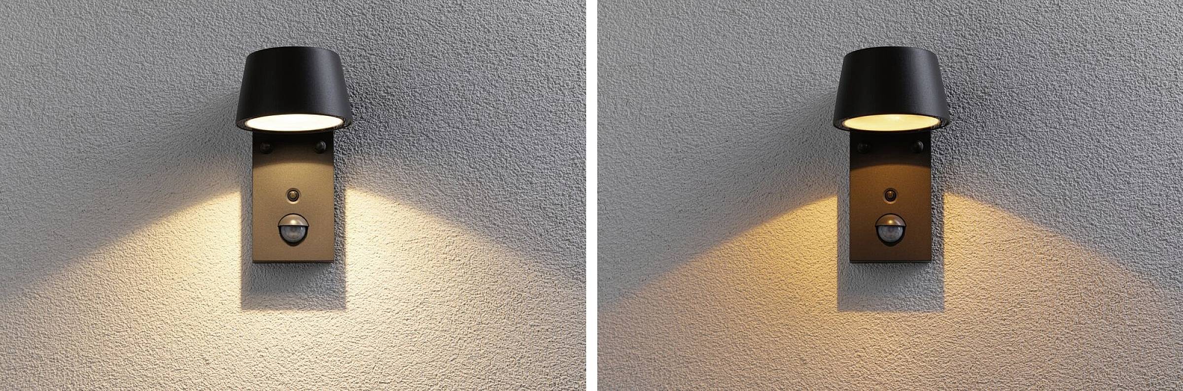 Dvije moderne, crne vanjske zidne lampe na zidu koje emitiraju blijedo, toplo svjetlo prema dolje. Pogodne za stilsko vanjsko osvjetljenje.