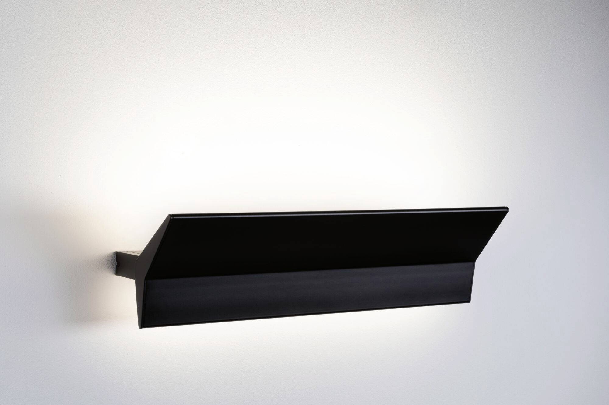 Crna zidna lampa jednostavnog, modernog dizajna koja raspršuje difuzno svjetlo na zid. Idealna za minimalistički uređene prostore.
