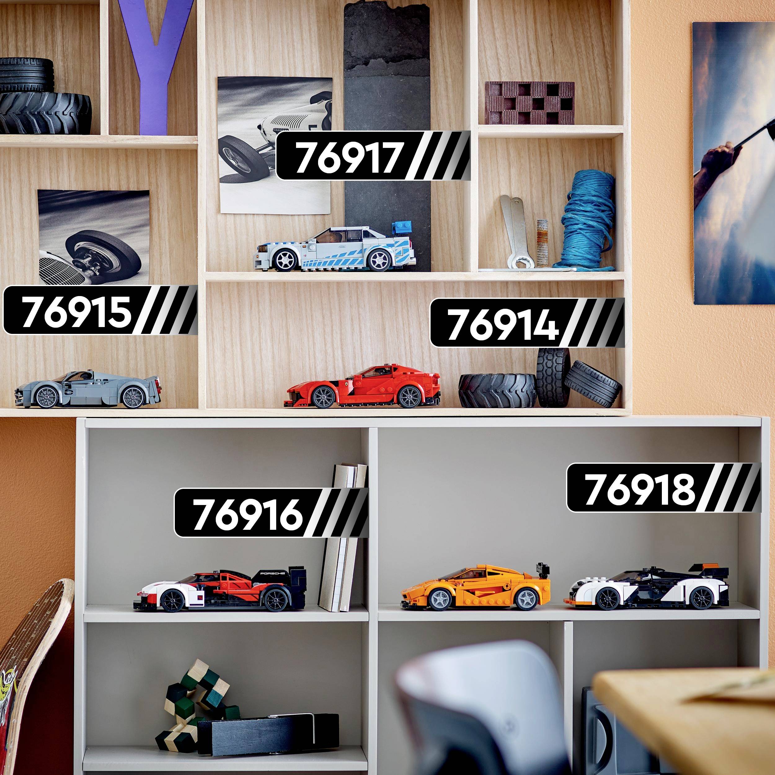 Polica sa igračkim autićima u različitim bojama i brojevima: 76915, 76917, 76914, 76916, 76918.