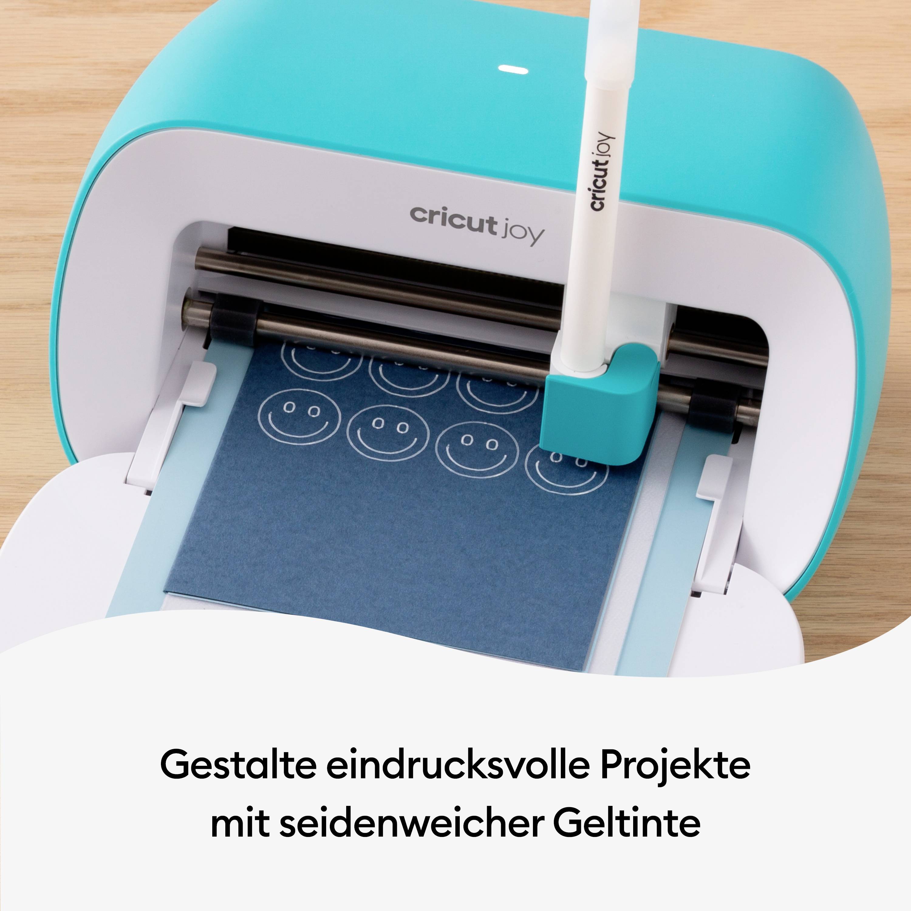 Cricut Joy mašina koja na plavom papiru gelom za pisanje crta smiješna lica. Tekst: 'Oblikuj impresivne projekte'.