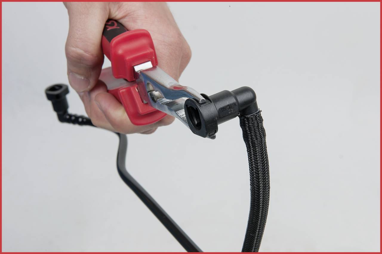 Ruka drži crveni kabel za paljenje koji je pričvršćen za crni kabel.