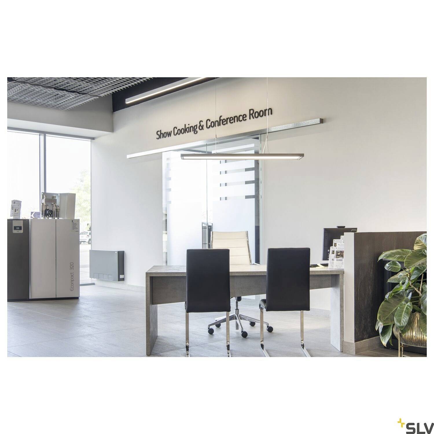 Moderan konferencijski prostor s stolom i tri stolice. U pozadini stoji natpis 'Show Cooking & Conference Room'.