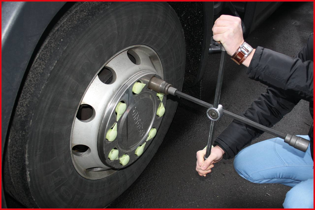 Osoba mijenja automobilske gume križnim ključem, što prikazuje upotrebu alata prilikom zamjene guma.
