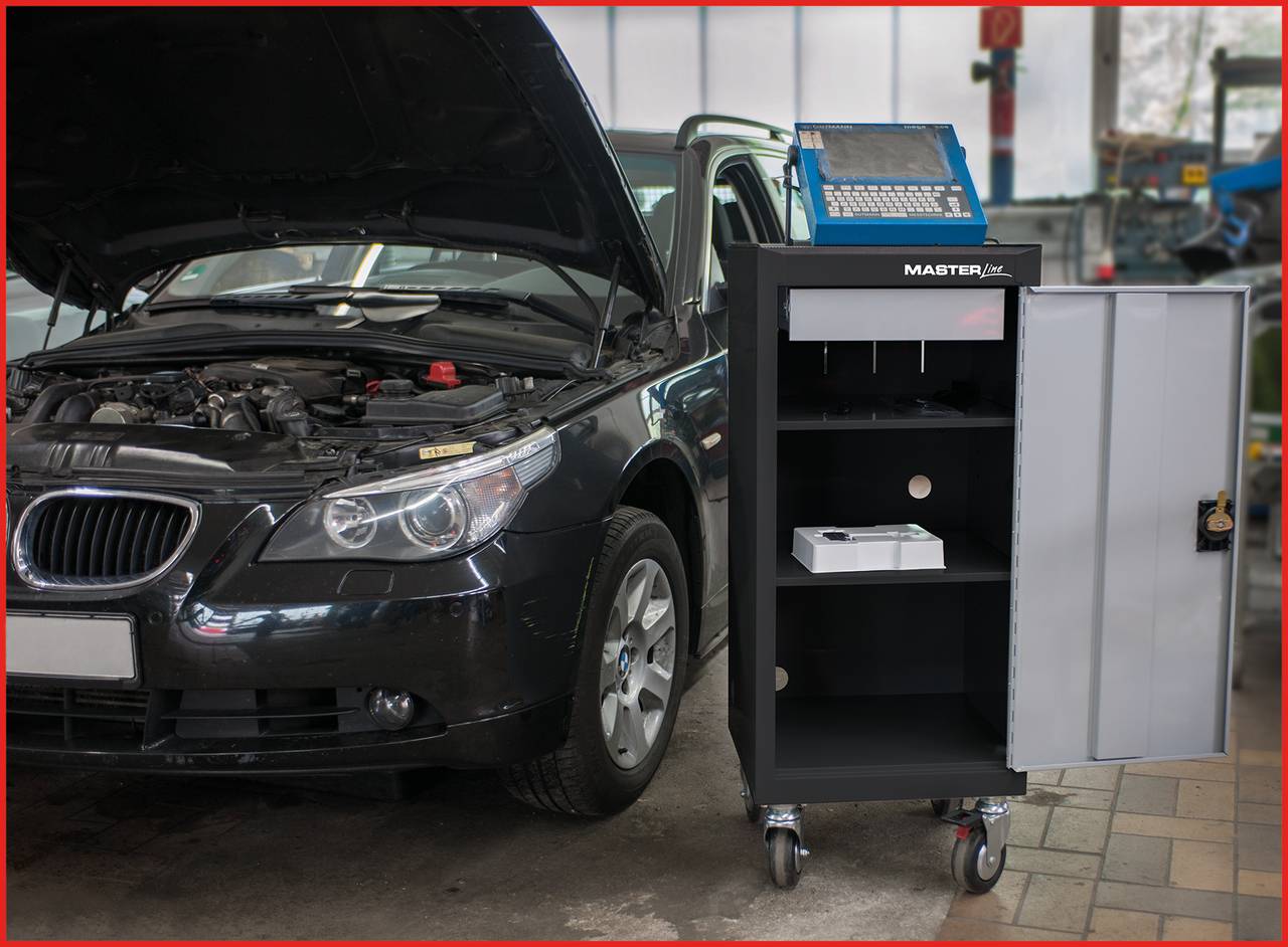 Automobil s otvorenim poklopcem motora u radionici; pored njega kolica za alat s računalom.