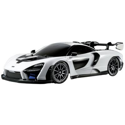 Bijeli sportski automobil s crnim krovom i akcentima, aerodinamičkog dizajna i velikog stražnjeg spojlera, stoji na sivoj pozadini.