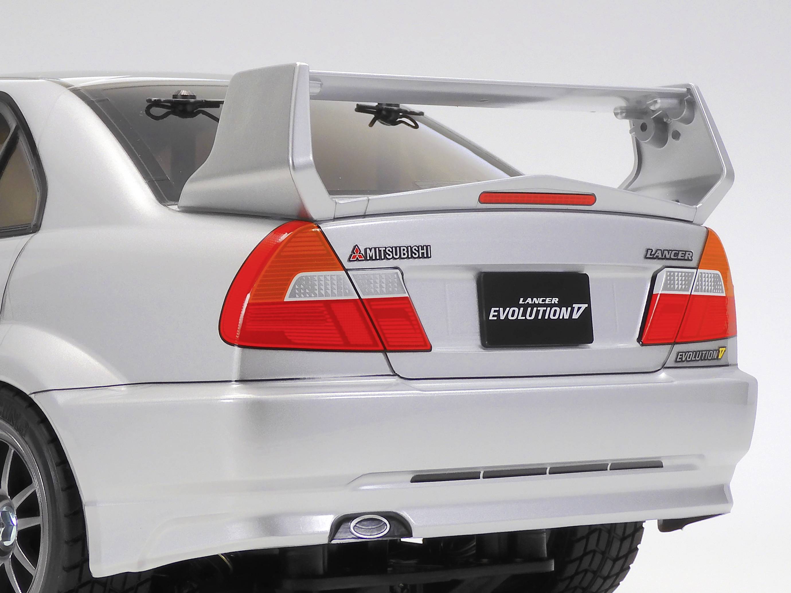 Srebrni Mitsubishi Lancer Evolution s velikim stražnjim krilom, pogled straga.