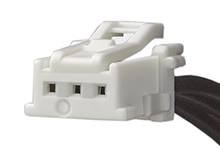 Bijeli trostruki utikač crne boje kabela, često korišten u elektroničkim uređajima za spajanje komponenti.