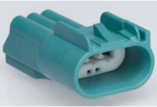 Pravokutni plastični utikač tirkizne boje sa tri unutarnja kontaktna punkta, vjerojatno za električne spojeve.