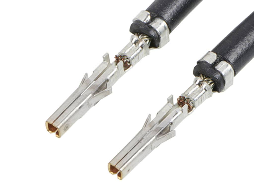 Dva metalna konektorska spoja sa crnim kabelskim priključkom, prikazana u detalju. Namijenjeni su za električne povezivosti.
