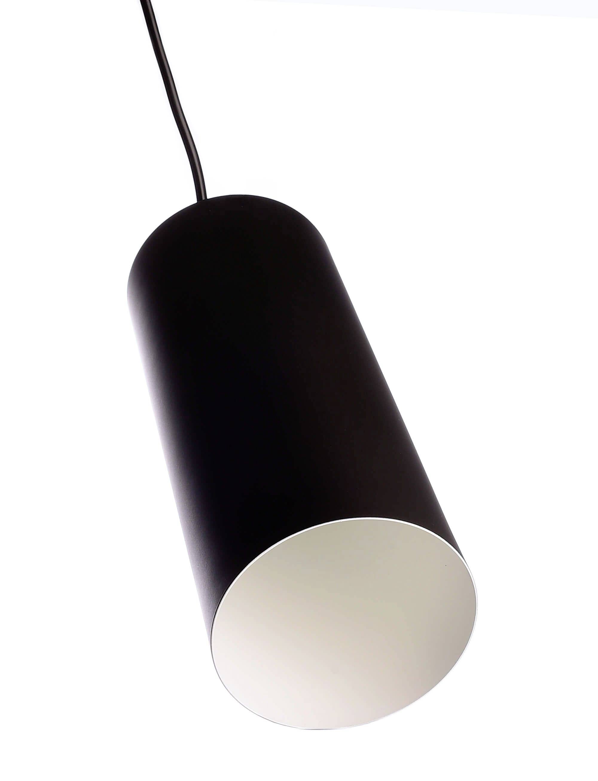 Crna, cilindrična viseća lampa pred bijelom pozadinom, obješena na kabelu. Minimalistički dizajn za moderne prostore.