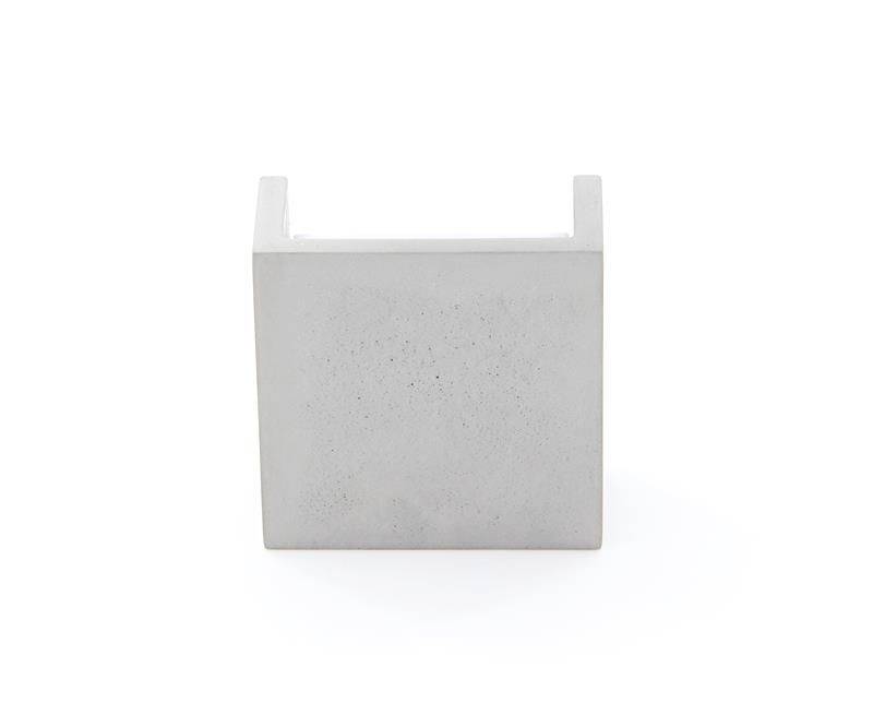 Minimalistički dizajniran objekt od betona u obliku kocke, vjerojatno dekorativni element ili komad namještaja.