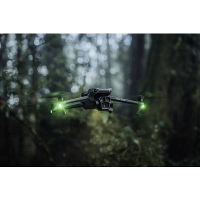 Dron sa zelenim svjetlećim svjetlima lebdi u maglom obavijšenoj šumi, okružen nejasnim drvećem.